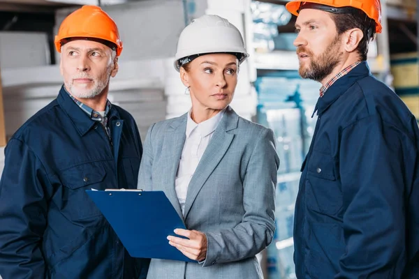 Male Workers Helmets Female Inspector Clipboard Warehouse — Stock Photo, Image