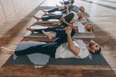 Seniorengruppe dehnt sich in Yogamatten im Studio
