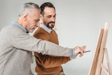 iki erkek sanatçı sanat dersinde şövale seyir yan görünüm