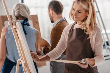 Palet tutarak ve şövale üzerinde sanat dersinde yetişkinler için resim güzel Olgun kadın