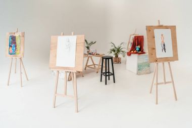 easels with paintings in empty art studio clipart