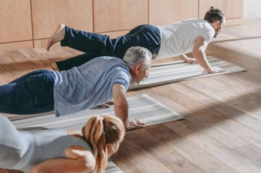 Grup pratik yoga Studio paspaslar üzerinde insan
