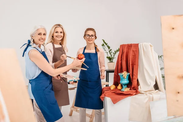 Tři Ženské Umělců Usmívající Kameru Připravené Malování Zátiší Ateliéru — Stock fotografie