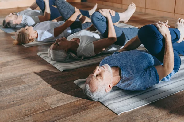 工作室中伸展瑜伽垫的老年人组 — 图库照片