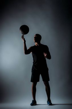 Afrika kökenli Amerikalı sporcu iplik basketbol topu üstünde parmak karanlık odada
