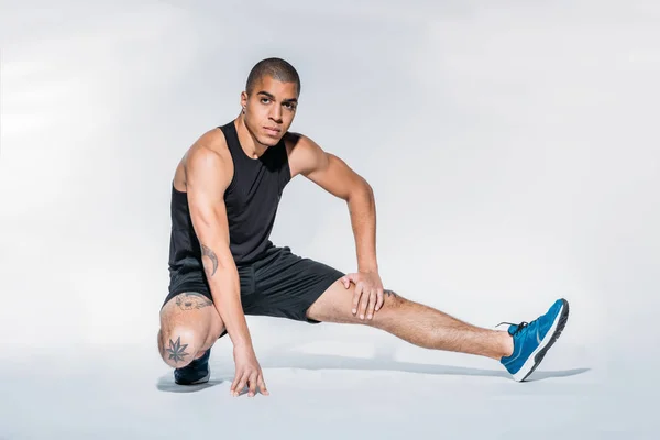 Afroamerikanska Sportsman Stretching Benen Och Tittar Kameran — Stockfoto