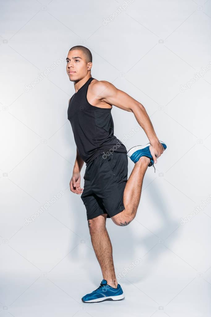 african american sportive man stretching legs