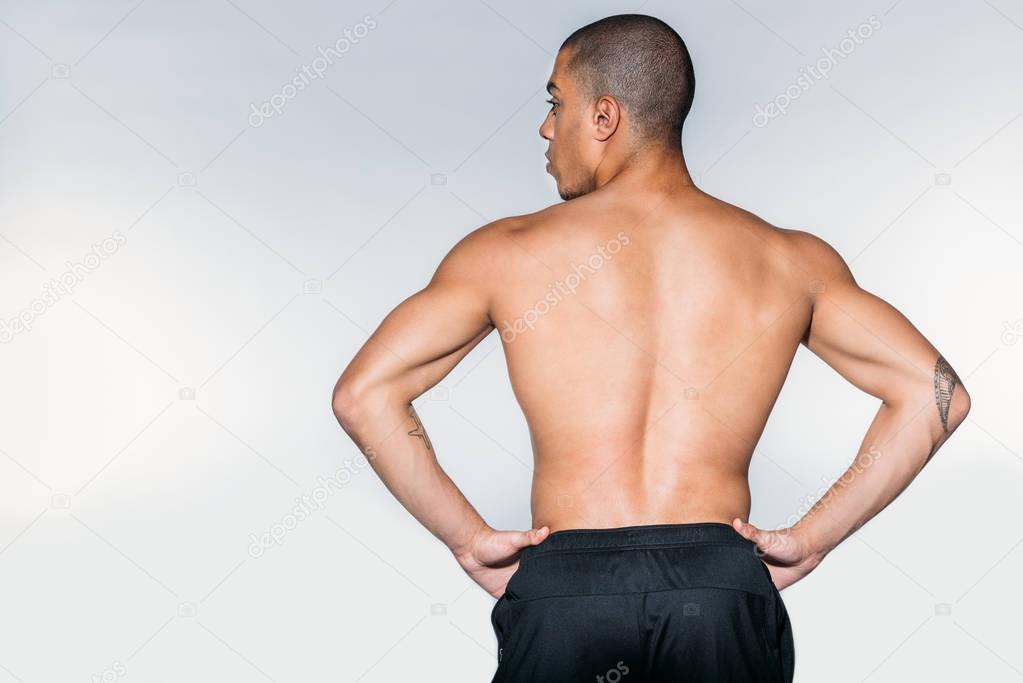 rear view of shirtless muscular african american sportsman standing isolated on white