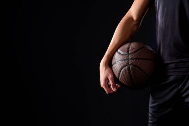 cropped shot of basketball player with ball isolated on black clipart