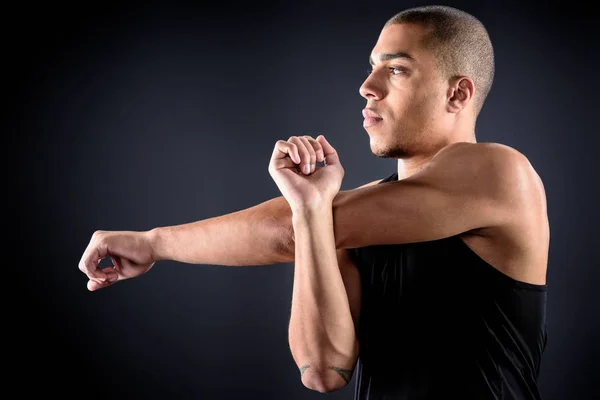 Young African American Sportsman Stretching Arms Black — Free Stock Photo