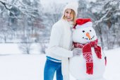 portrét mladé ženy veselá stál sněhulák a při pohledu na fotoaparát