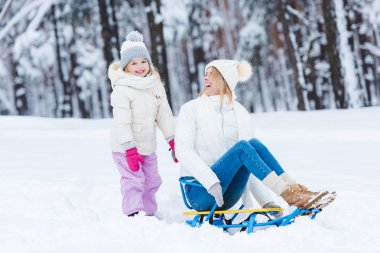 mutlu kızı ve annesi birlikte kış parkta sledging