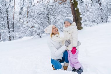 mutlu anne ve kızı kış parkta sarılma