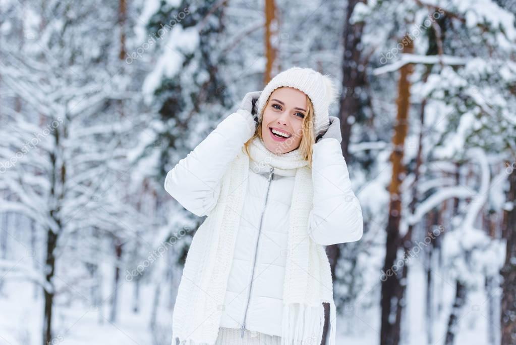 portrait of beautiful happy woman in snowy winter forest