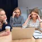 Team di lavoro hanno discussione mentre seduto a tavola con il computer portatile