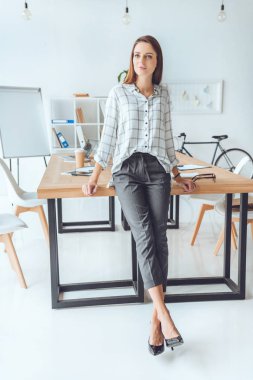 kadın masanın üzerine eğilerek ve uzak ofis alanı seyir gömlekli 