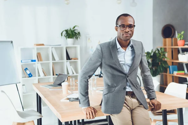 Afrikanska Mannen Lutar Sig Bordet Och Tittar Kameran Office Space — Stockfoto