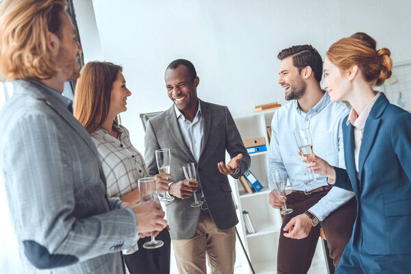 business team celebrating with beverage in glasses at office space 