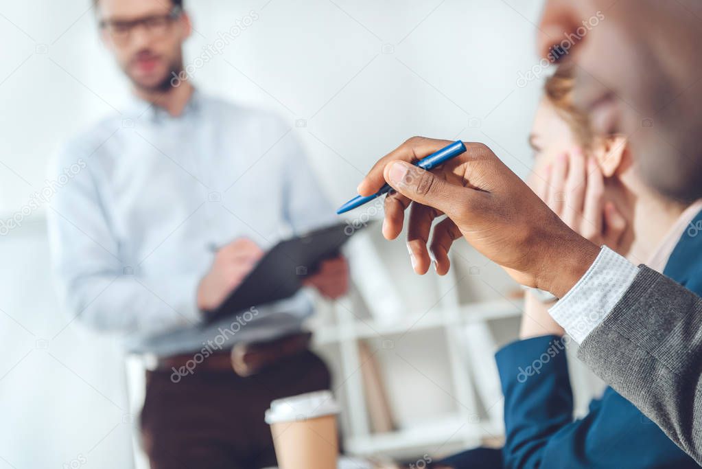 african man holding pen in hands while sitting at office space