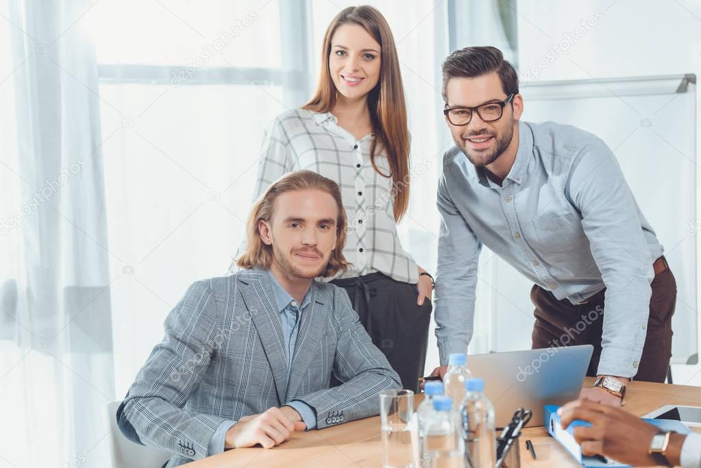 business team looking at camera at office space 
