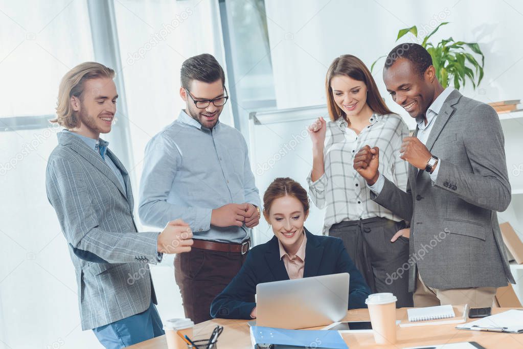 business team standing against sitting woman at office space  