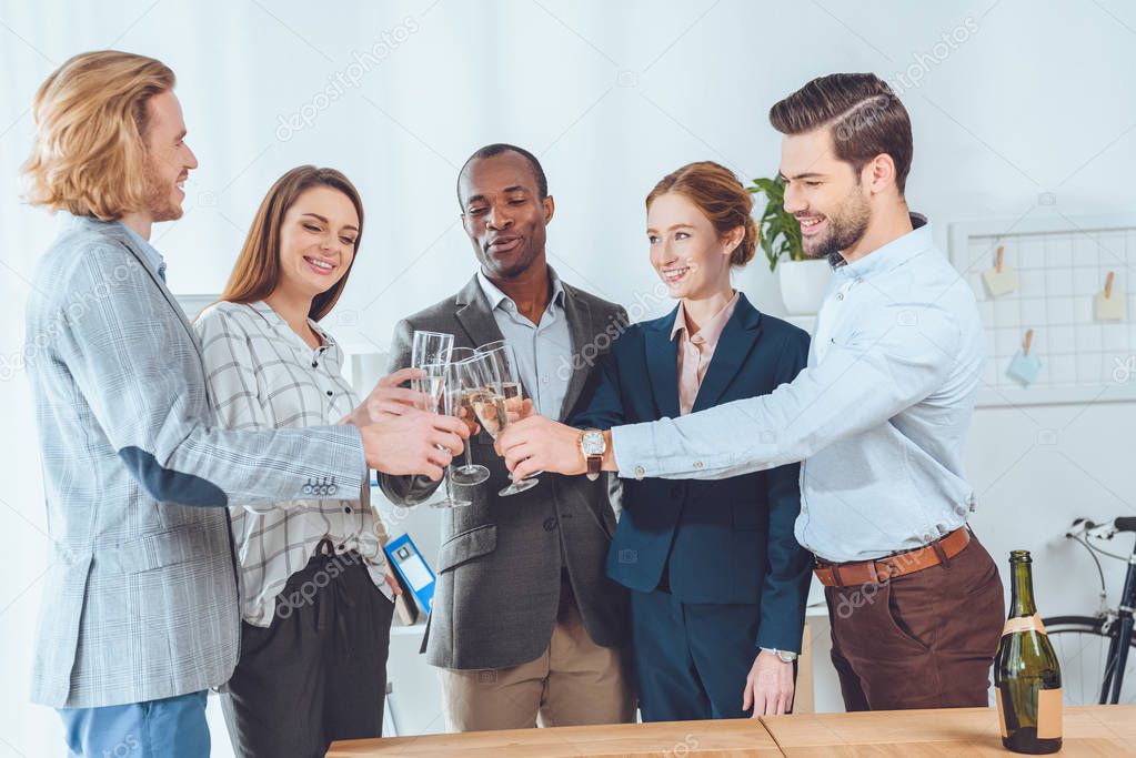 business team celebrating with beverage in glasses at office space   