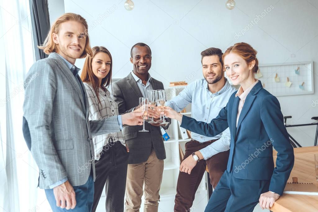 business team celebrating with beverage in glasses at office space  
