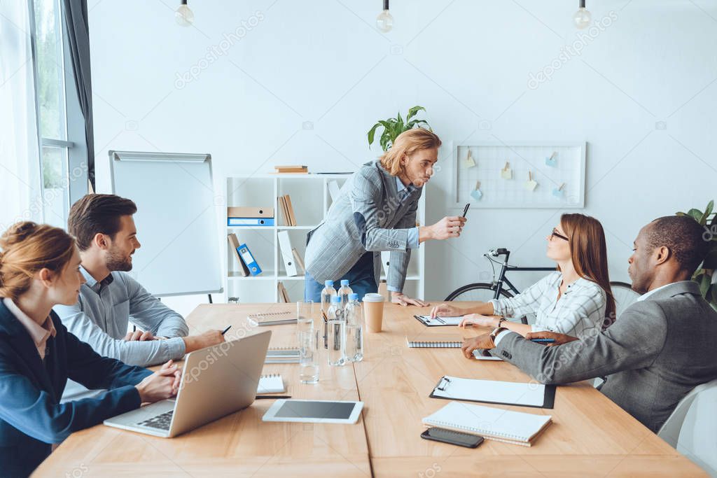 business team sitting at table and speaking at office space 