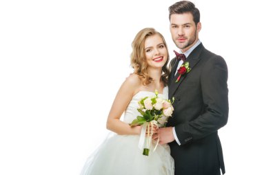 Düğün buketi ve izole üzerinde white tarafından yakınındaki damat ile gülümseyen gelin portresi