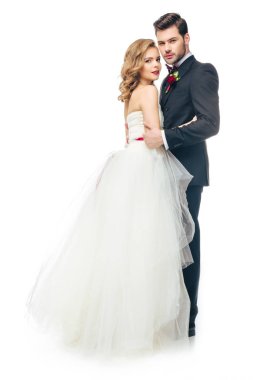 birbirlerine sarılma ve üzerinde beyaz izole kamera bakarak evlilik çift yan görünüm