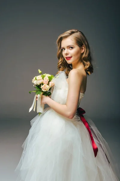 花のブーケとウェディング ドレスの花嫁の側面図 — ストック写真