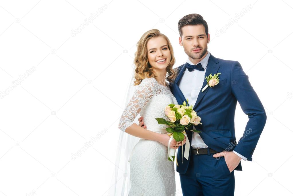 portrait of smiling bride with wedding bouquet and groom isolated on white