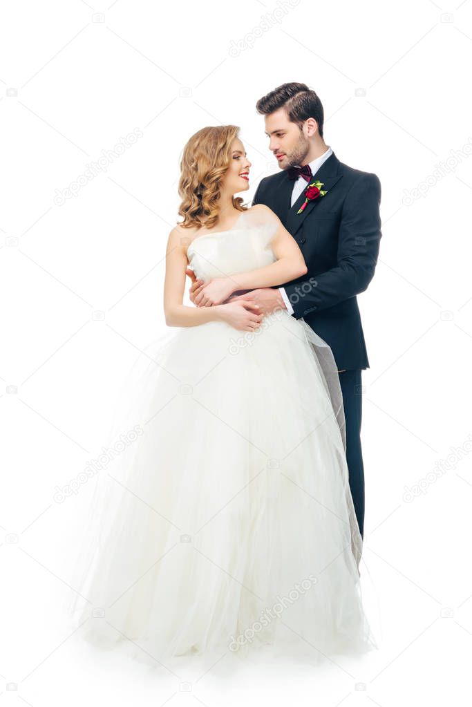 young wedding couple looking at each other isolated on white