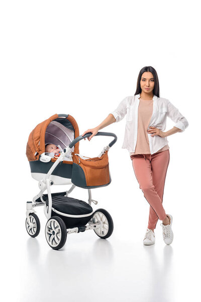 молодая женщина с младенцем ребенка в детской коляске изолированы на белом
