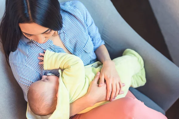 腕の椅子を自宅で休んで幼児 乳児を持つ母のオーバー ヘッド ビュー — ストック写真