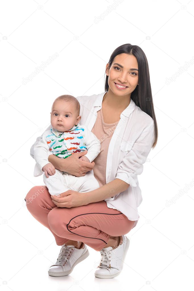 smiling young woman and cute little baby looking at camera isolated on white