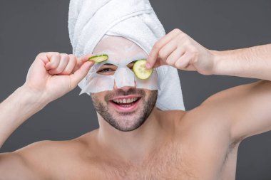 grey, cilt bakım kavramı izole kolajen maske ve salatalık dilimleri ile gülümseyen adam