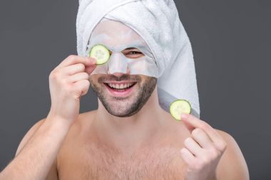 neşeli adam kolajen maske ile sakallı ve salatalık dilimleri, gri, izole cilt bakım kavramı