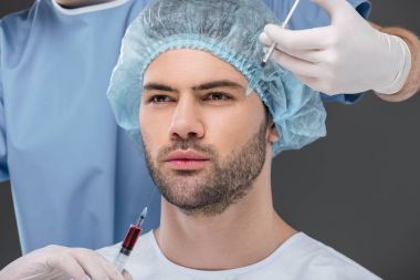 bearded handsome man in medical cap making beauty injections, isolated on grey clipart