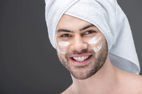 Uomo Sorridente Asciugamano Con Crema Sul Viso Isolato Grigio — Foto Stock