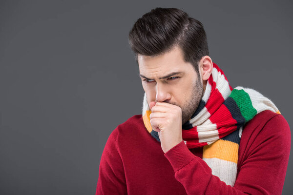 sick man coughing in warm scarf, isolated on grey