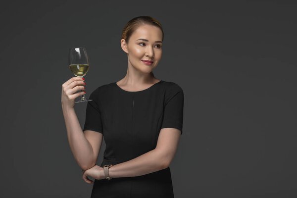 beautiful smiling kazakh woman holding glass of wine isolated on grey