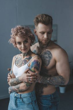 Genç çift yatak odasında sarılma dövme