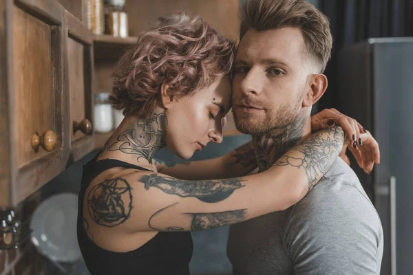 Joven Pareja Tatuada Abrazando Cocina — Foto de Stock