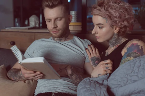 Pareja Tatuada Descansando Leyendo Libro Casa — Foto de stock gratuita