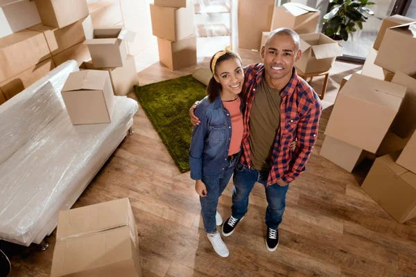 Happy African American Couple Hugging New Home Cardboard Boxes — Stock Photo, Image