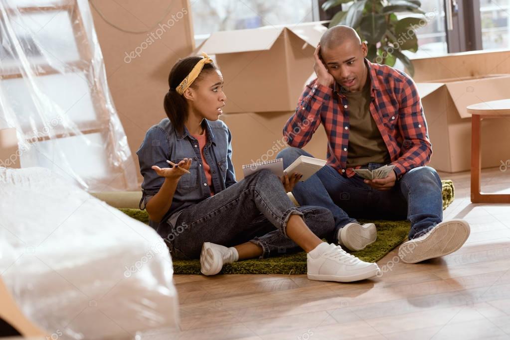 african american couple calculating budget in new apartment 