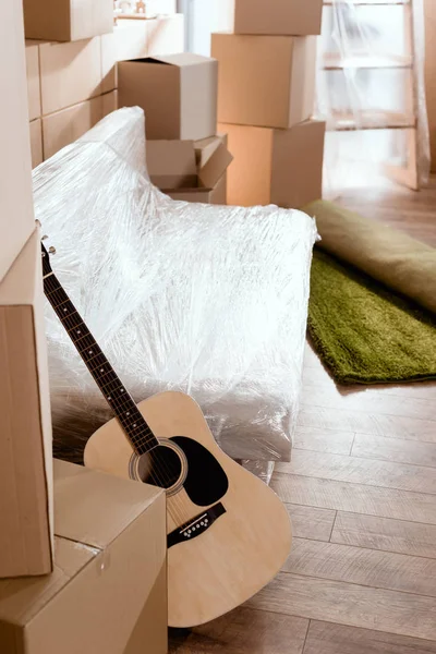ソファ アコースティック ギターは新しい家でカーペットや段ボール箱を圧延 — ストック写真