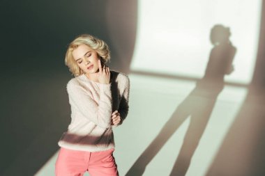 şehvetli sarışın kızın stüdyoda poz moda pembe giysiler içinde yüksek açılı görünüş