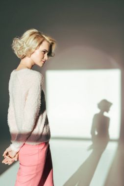 beautiful blonde girl looking away while posing in studio clipart